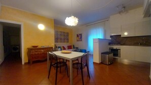 A compact living space with a dining area, kitchenette, and a small seating area. - Conti Apartment in Firenze (Florence)