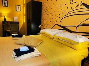 A hotel room with a bed, pillows, a chair, a desk, and a lamp. - LH 51 Neapolitan Rooms (Naples)