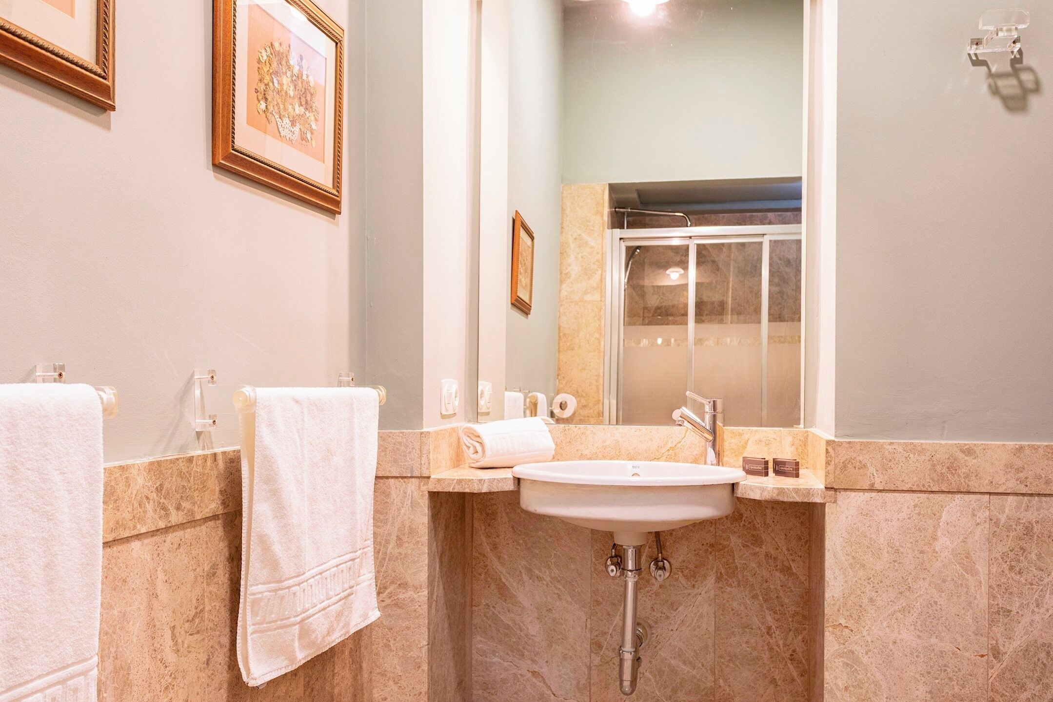 A bathroom with a sink, mirror, and towel rack.