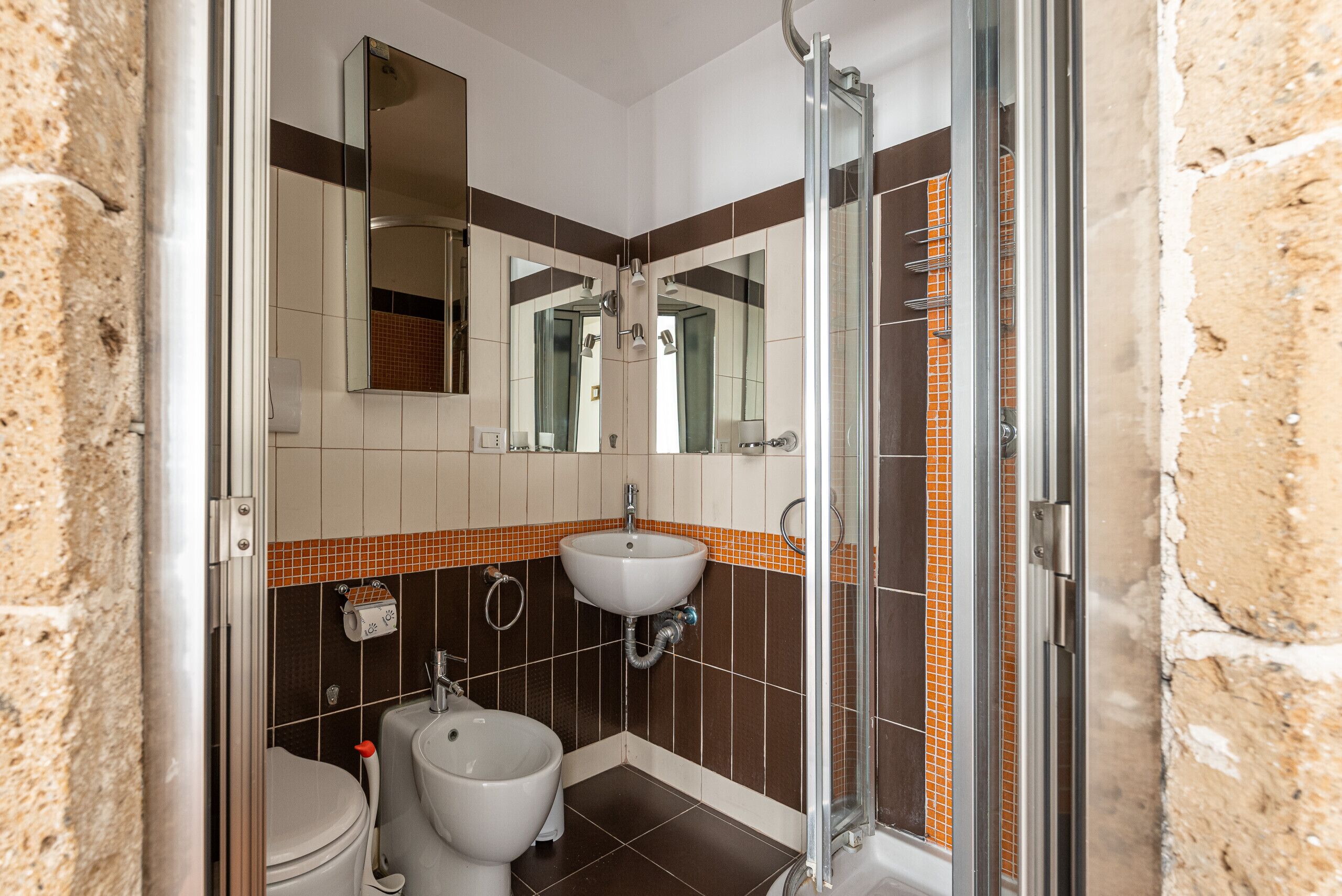 Un bagno con doccia, lavandino e WC.