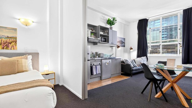 A modern apartment with a kitchenette, a dining area, and a bedroom. - Stay in Aucklands Iconic Queen St  Zodiak Stays (Auckland)