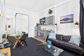 Ein kompakter Wohnbereich mit Küchenzeile, Essbereich und einer Sitzecke mit einer Couch.