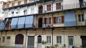 A multi-story building with balconies, potted plants, and bicycles.
