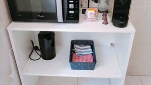 Keittiön työtasolla on mikroaaltouuni, vedenkeitin, kahvinkeitin ja Krups-merkkinen kahvimylly.