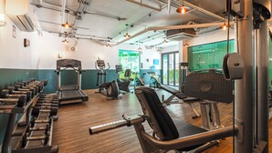 Et fitnesscenter med løbebånd, håndvægte og træningsmaskiner.
