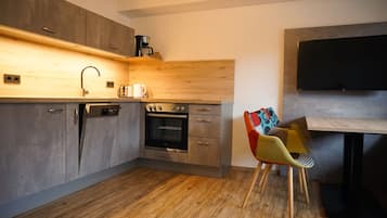 A modern kitchen with a built-in oven, a coffee maker, and a wooden countertop.