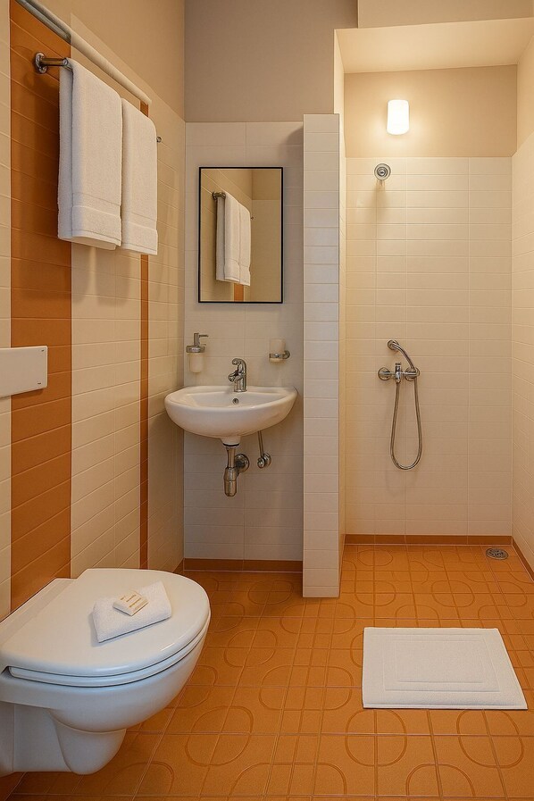 A bathroom with a toilet, sink, mirror, and shower. - Urban Stay (Bengaluru)