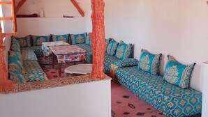 Un salón acogedor con un sofá estampado, una mesa de centro y una alfombra.