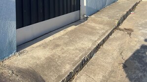 Een gebouw met een blauwe gevel, een zwart metalen hek en het nummer 222 op de muur.