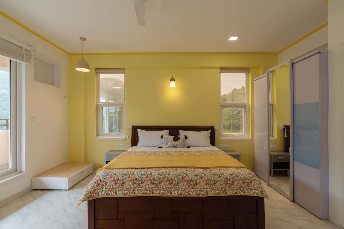 A bedroom with a bed, bedside tables, a window, and a wardrobe.