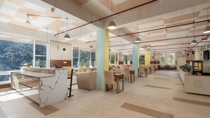 A spacious dining area with high ceilings, pendant lighting, and large windows offering a view of the outdoors. - Better Life Homes - For active seniors above 50 years (Solan)