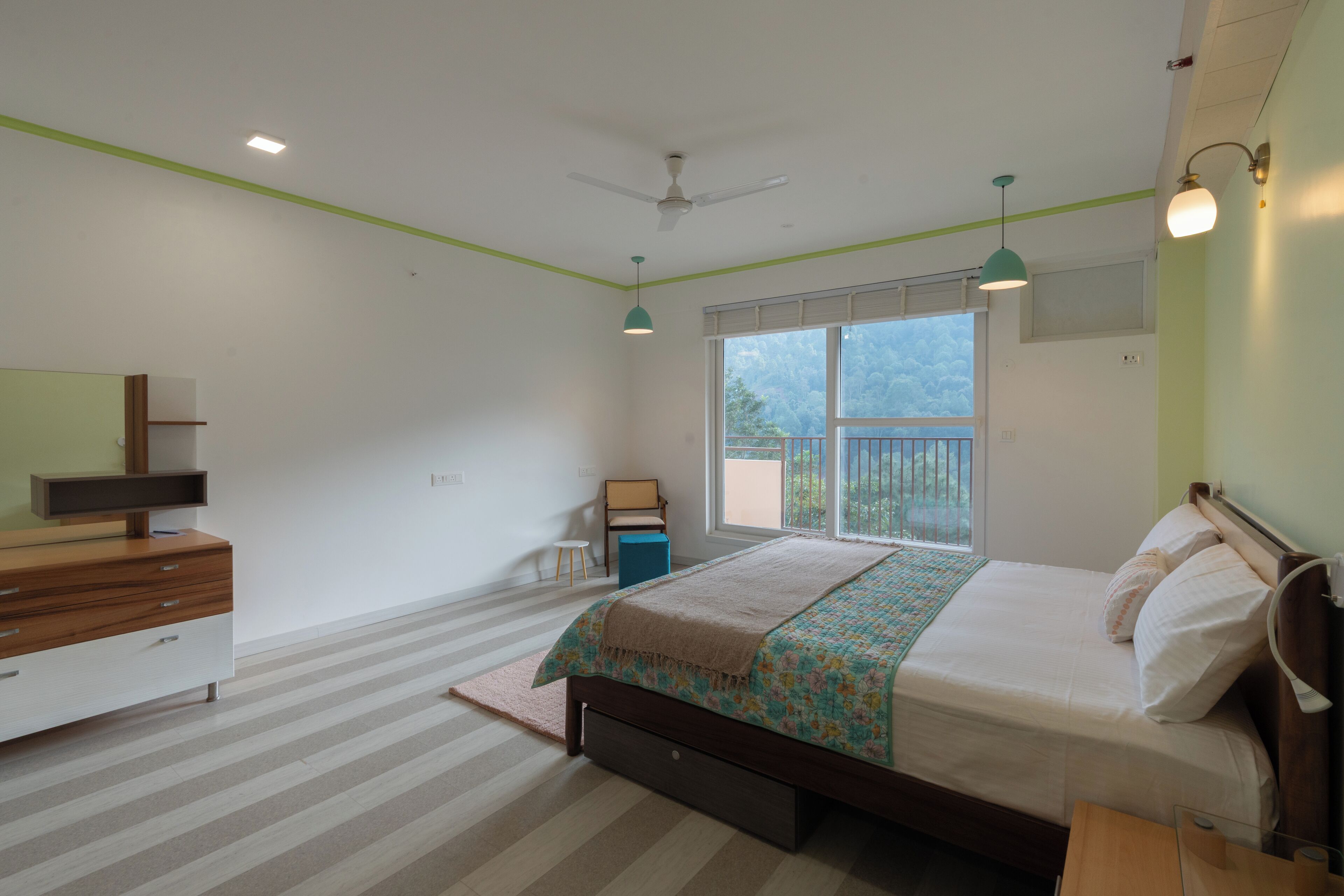 A bedroom with a bed, a dresser, a chair, a desk, and a window with a view of the outdoors.
