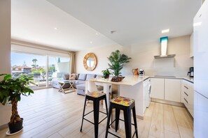 Una cocina moderna con comedor, un ventanal grande y una planta en maceta.