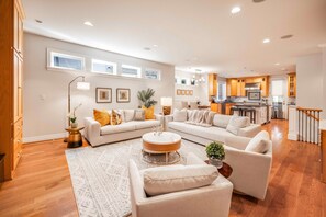 A spacious living room with a large L-shaped sofa, a coffee table, and a dining area in the background. - Grand Bellevue DT Villa 5,010 sqft, near BV Square (Bellevue)