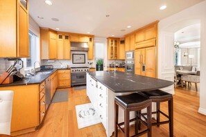 A spacious kitchen with wooden cabinets, a large island, and modern appliances.