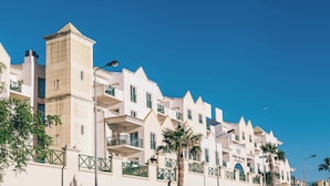 A row of white buildings with balconies and palm trees. - Relaxing Getaway Awaits! Comfortable 1BR with Kitchen & Balcony, 2 Onsite Pools! (Albufeira)