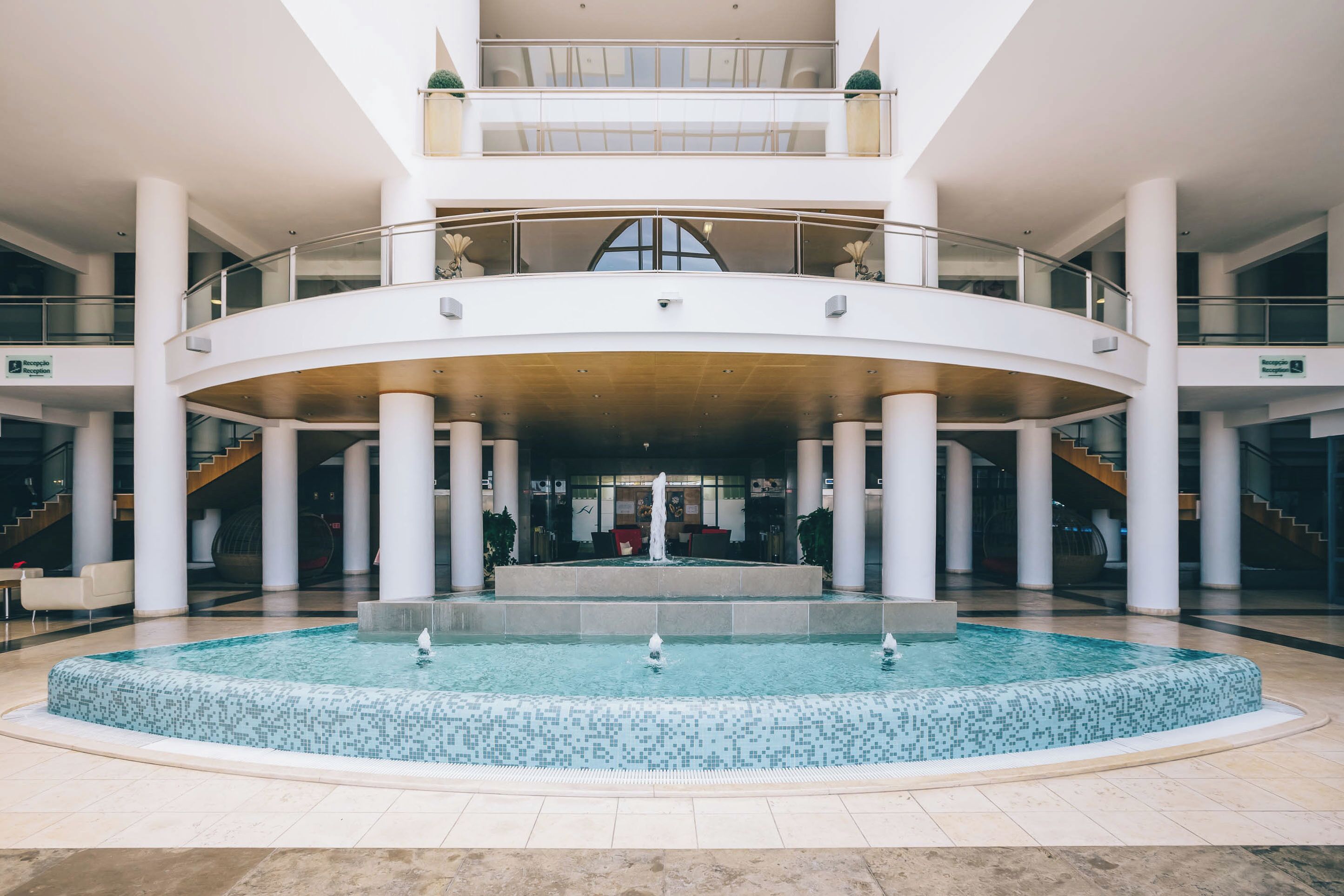 A spacious atrium with a central fountain, multiple levels, and a modern architectural design.