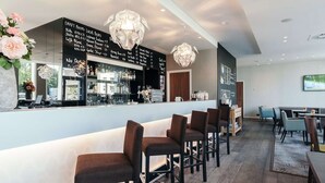 A modern bar area with a black menu board listing draft beers, a bar counter, and seating with bar stools. - Modern Stay in Flemish Ardennes, Ideal for Cyclists | 3 Units | Bike Storage (Oudenaarde)