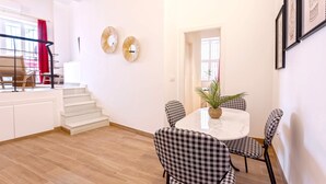 A dining area with a round table, checkered chairs, and a potted plant. - Luxury Apartment in Sevilla Center. Pajaritos V (Seville)