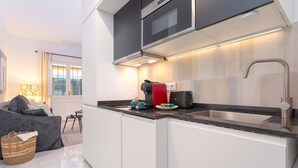 A modern kitchen with white cabinets, a stainless steel sink, and a built-in oven. - Cozy Apartment in Sevilla Center. Baños IV (Seville)