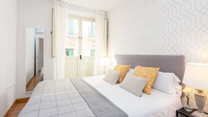 A hotel room with a bed, a nightstand, a lamp, and a view of the outside. - Modern Apartment in Prime Location. Marín García III (Málaga)