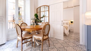 Un comedor con una mesa y sillas de madera, un espejo y vistas a un balcón.