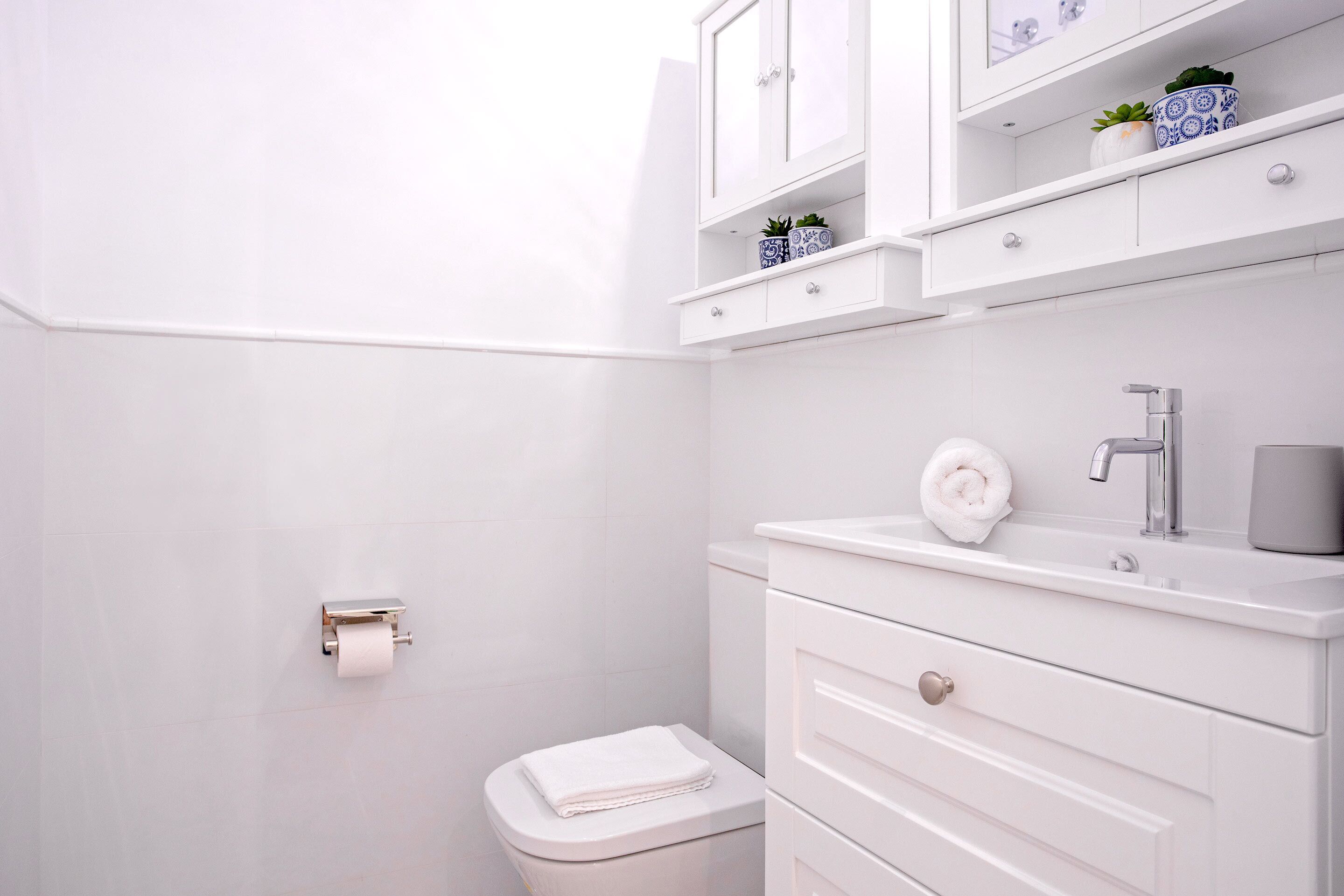 Ein modernes Badezimmer mit Toilette, Waschbecken und Ablagekörben.
