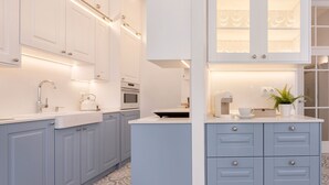 Una cocina moderna con armarios blancos, una isla central y electrodomésticos integrados.