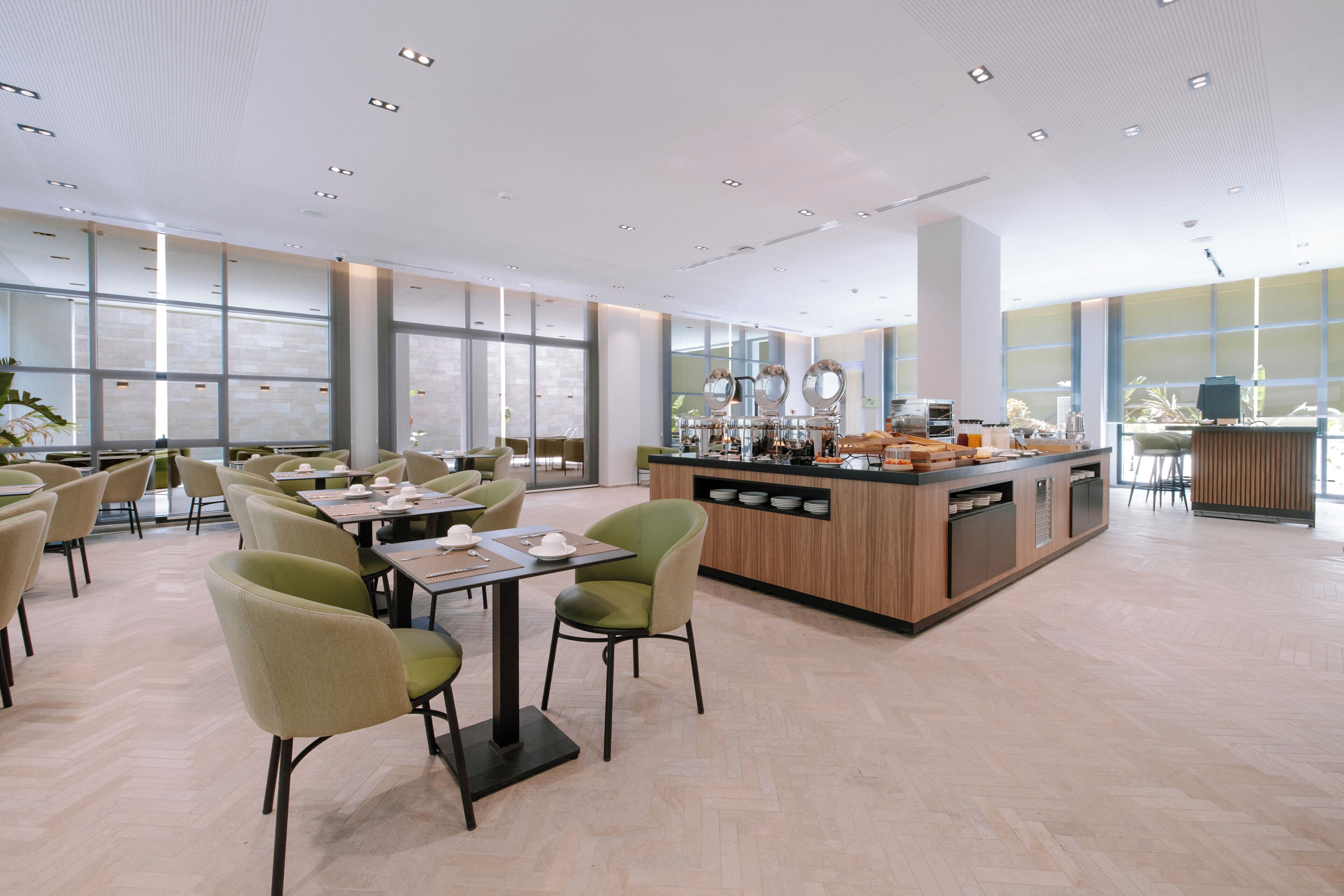 Un vaste espace dédié à la salle à manger, doté de hauts plafonds, de grandes fenêtres et d’un comptoir central avec un espace pour préparer le café.