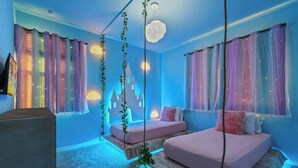 A bedroom with two beds, a hanging plant, and a wall-mounted light fixture. - 8905 Solara 9bd 22sleep/pool (Davenport)