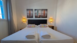 A double bed with two pillows, a headboard, and two bedside tables with lamps. - 182 Livingtarifa Famara (Tarifa)