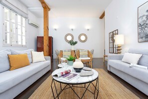 A modern living room with a sofa, armchairs, a coffee table, and decorative items. - Wonderful Duplex Located in the Center of Malaga. Larios II (Málaga)