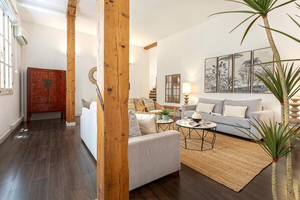 A living room with a sofa, coffee table, and a painting on the wall.