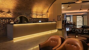 Eine moderne Lobby mit Empfangstresen, Ledersitzmöglichkeiten und einer Ziegelwand.