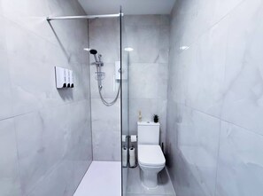 A modern bathroom with a glass-enclosed shower, a white toilet, and a marble-tiled wall. - Elegant 1bed flat, sleeps 3, Pet Friendly, Free parking, contractors welcome (Pudsey)