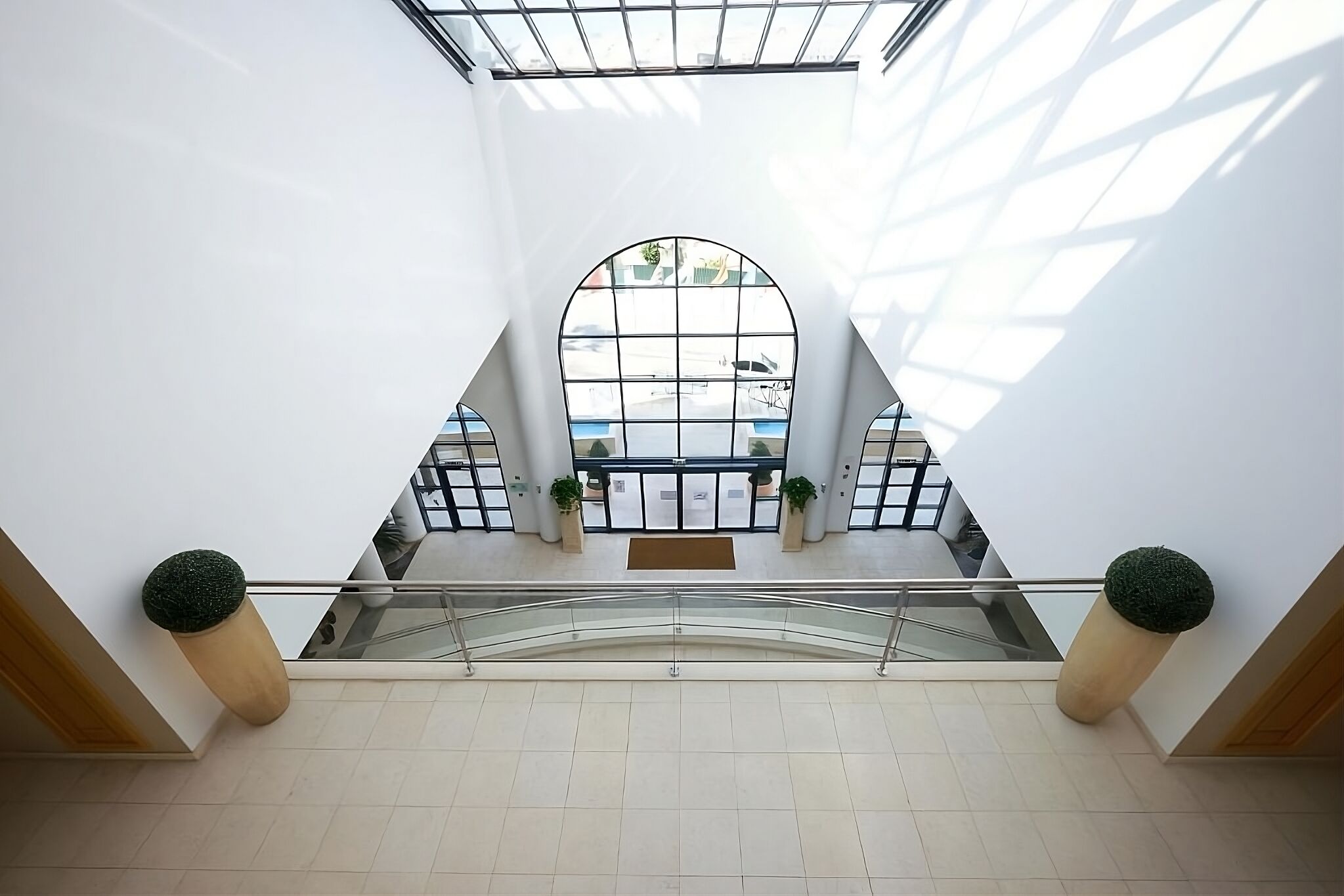 Tilava aula, jossa on korkea katto, suuret ikkunat ja keskeisellä paikalla sijaitseva portaikko.