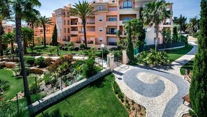 A multi-story hotel with balconies, a landscaped garden, and a paved pathway. - Boat Tour from Praia da Luz! Full Kitchen, Indoor and Outdoor Swimming Pools! (Luz)
