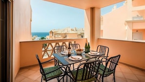 A balcony with a table set for two, a bottle of wine, and a bowl of bread. - Rare Find! Comfortable 2BR with Kitchen, 3 Swimming Pools, Free Parking! (Luz)