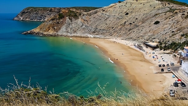 A coastal beach with clear turquoise waters, a sandy shore, and rocky cliffs. - Your Home Away From Home! Fully-equipped Kitchen, 3 Swimming Pool, Free Parking! (Luz)