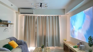 Un salon moderne avec un canapé, une table basse et un écran de télévision.