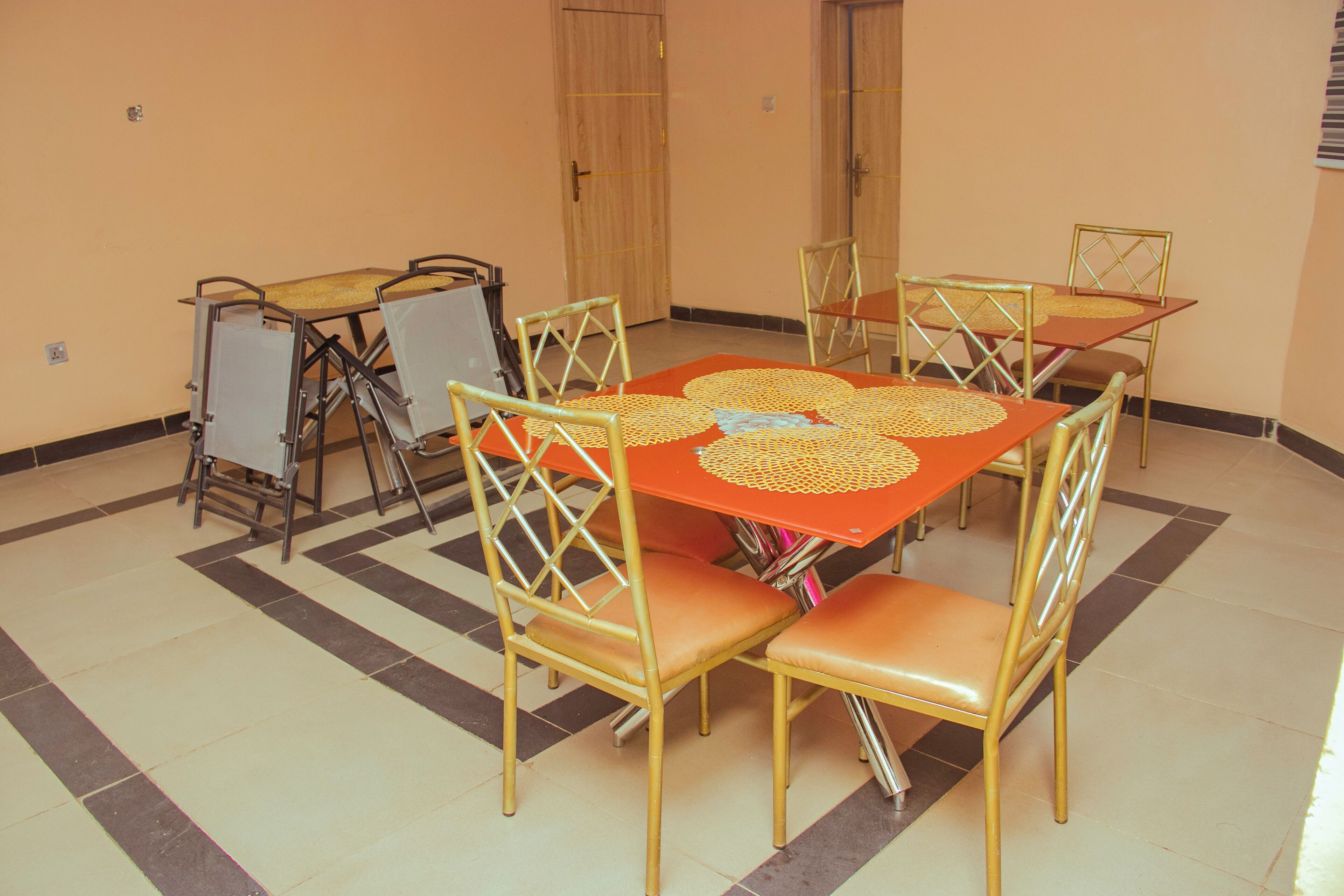 A dining area with a table and chairs, a door, and a tiled floor.