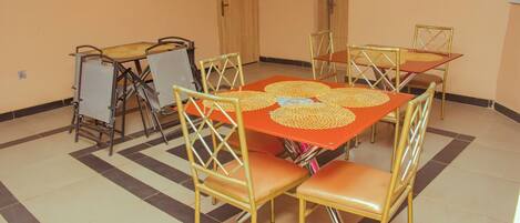 A dining area with a table and chairs, a door, and a tiled floor.