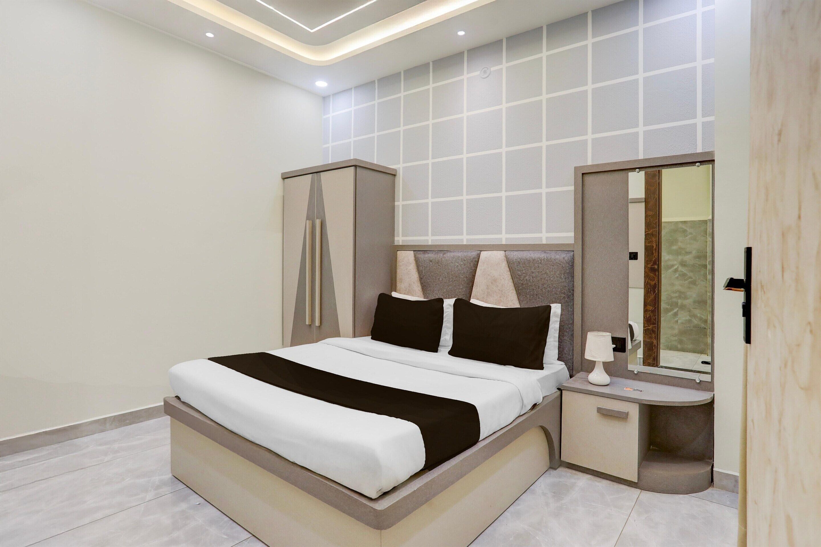 Un dormitorio moderno con una cama grande, mesitas de noche, un armario y un espejo.