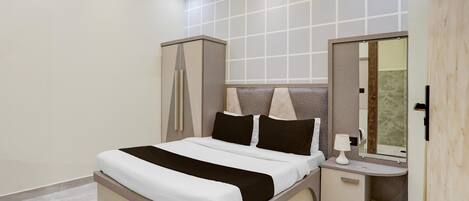 Un dormitorio moderno con una cama grande, mesitas de noche, un armario y un espejo.