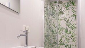Ein Badezimmer mit einem modernen Waschbecken, einer Toilette und einer Dusche.