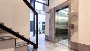 A modern interior with a staircase, elevator, and tiled flooring. - Modern Apartment in Seville. Corral del Rey II (Seville)