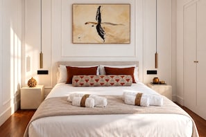 A spacious bedroom with a large bed, two nightstands, a wall-mounted artwork, and a wooden floor. - Genteel Home Corral del Rey II (Seville)