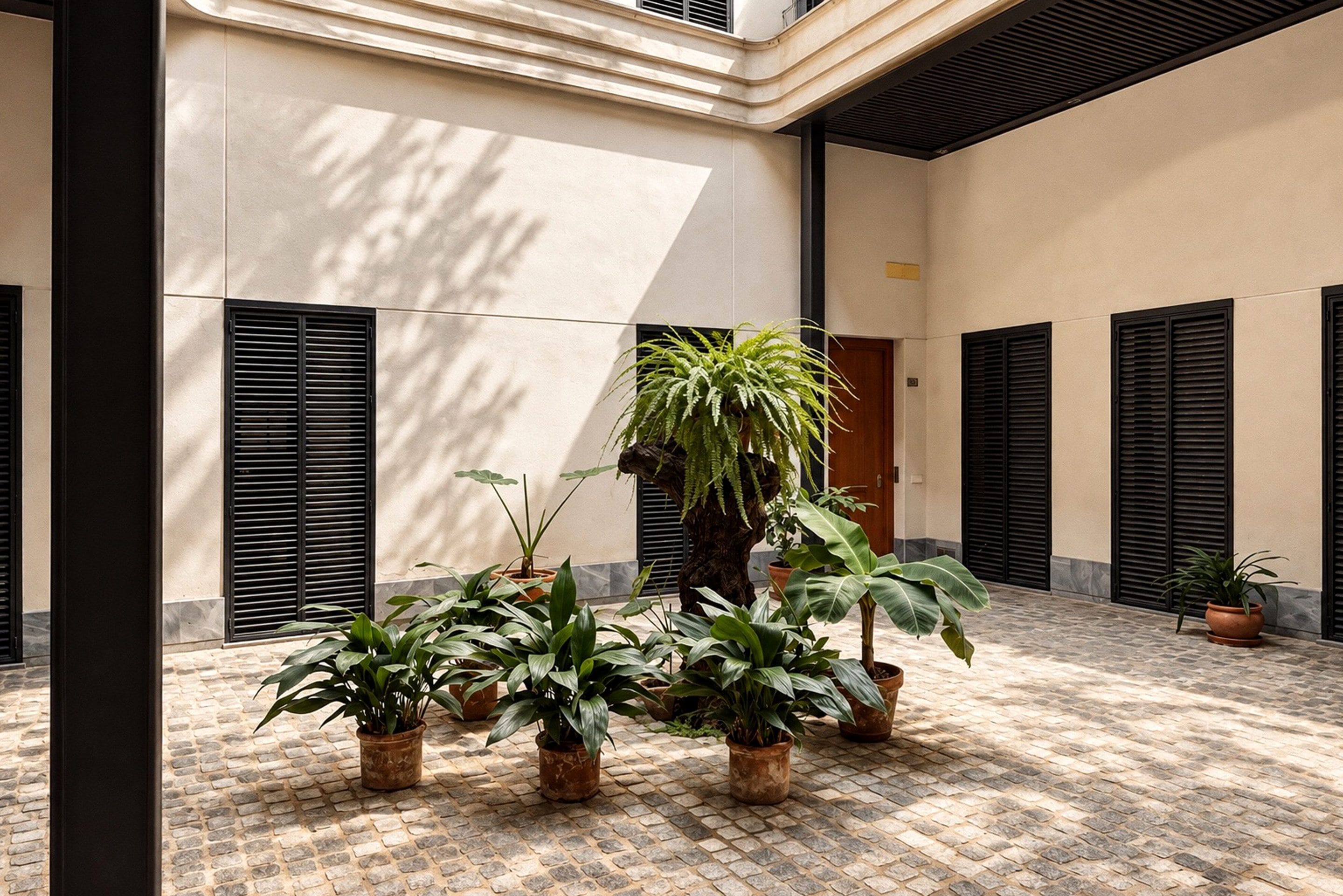 A courtyard with potted plants and a tiled floor.