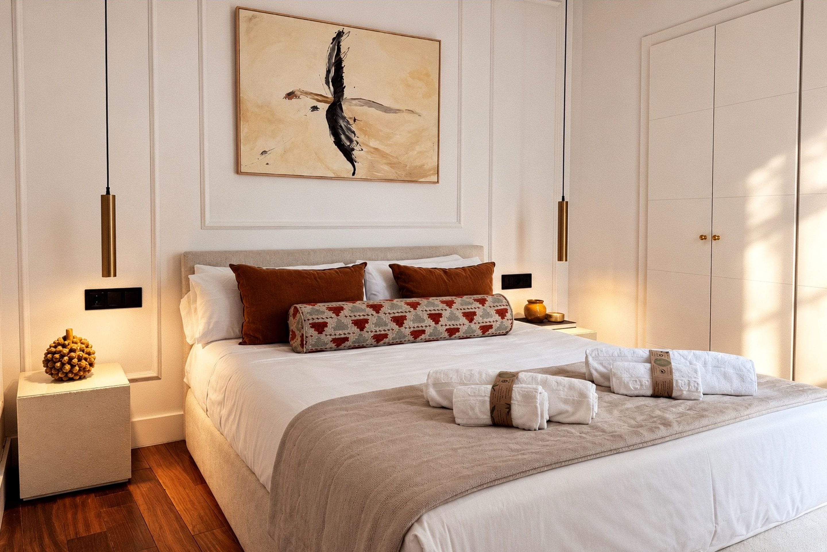 Una camera da letto con un letto grande, un comodino, un armadio e un'opera d'arte appesa al muro.
