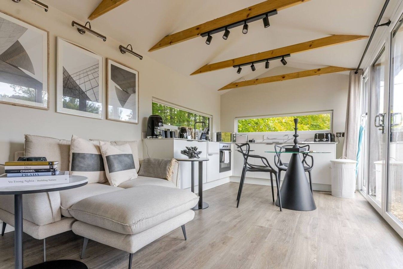 A modern interior with a sofa, a dining table, and a kitchen area.